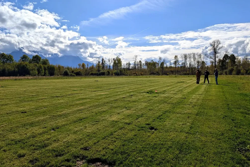A finished sports field stretching toward the mountains at Sik-E-Dakh