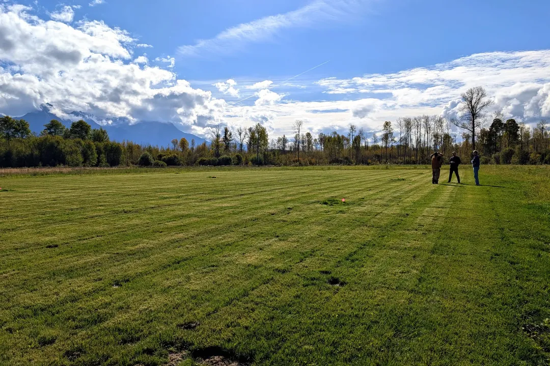 A finished sports field stretching toward the mountains at Sik-E-Dakh