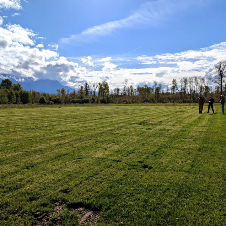 A finished sports field stretching toward the mountains at Sik-E-Dakh