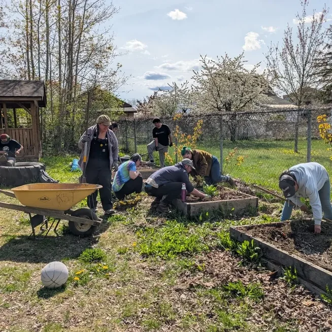 A crew rebuilding raised garden beds at the Kermode Friendship Society